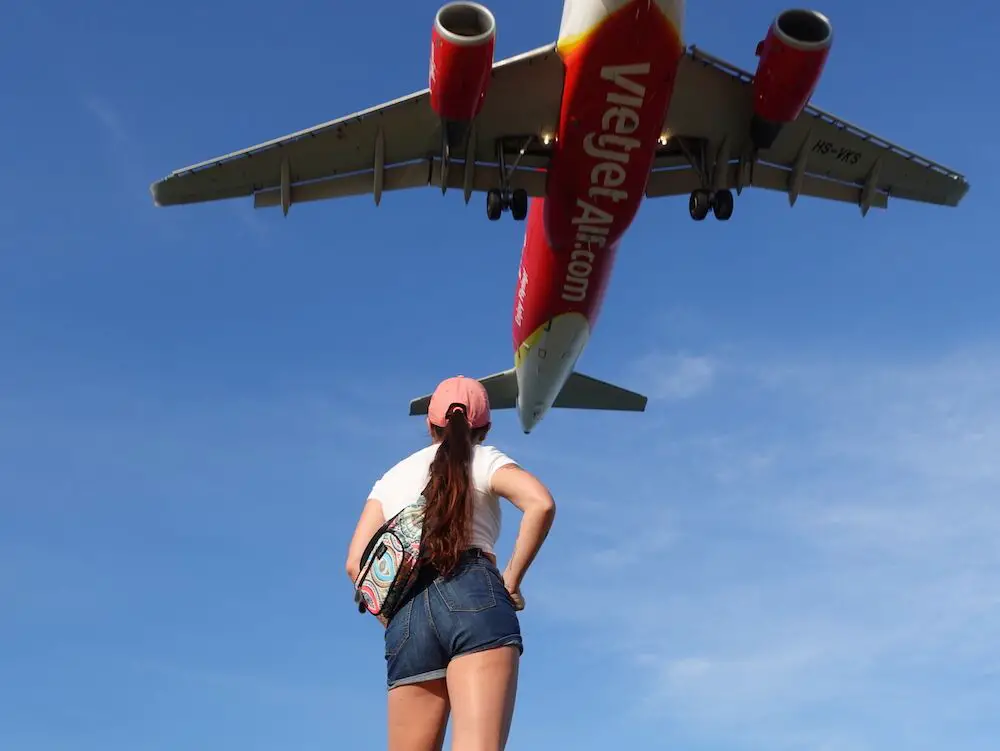 Woman looking at a flying plane