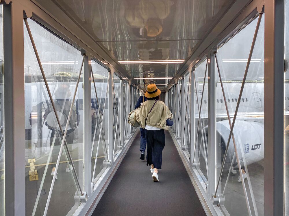 People walking on a jet bridge to their plane